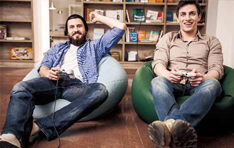A man in casual wear gaming on a beanbag