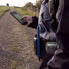  a man in the wildness operating his phone  