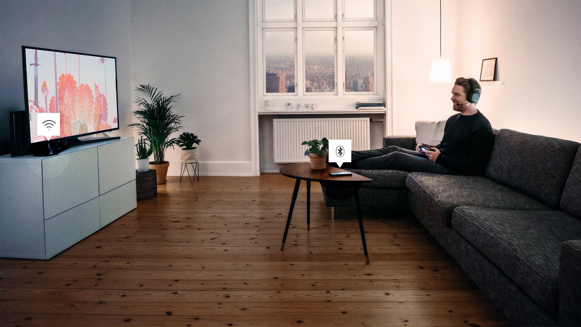 A man in his living room, on his couch, playing his playstation 4 while wearing the SteelSeries Arctis Pro headset