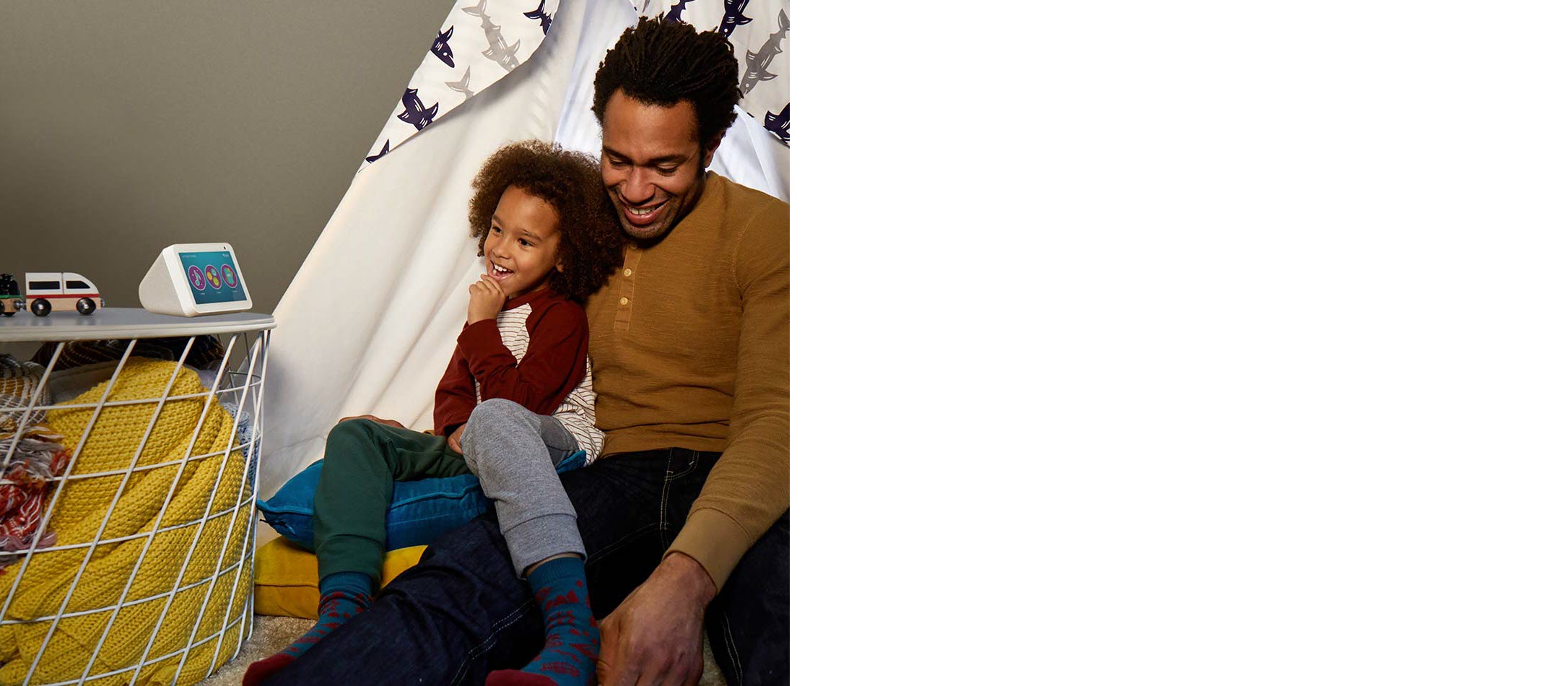 a colored man holding his daughter who is watching Echo Show 5