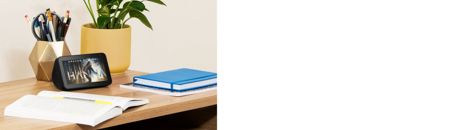 Echo Show 5 placed with several books on the desk