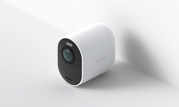 Wire-free arlo camera angled to the left at the edge of a white floor and wall