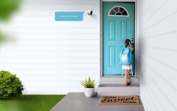 a young girl coming home to open her front door with the arlo camera mounted above to the left