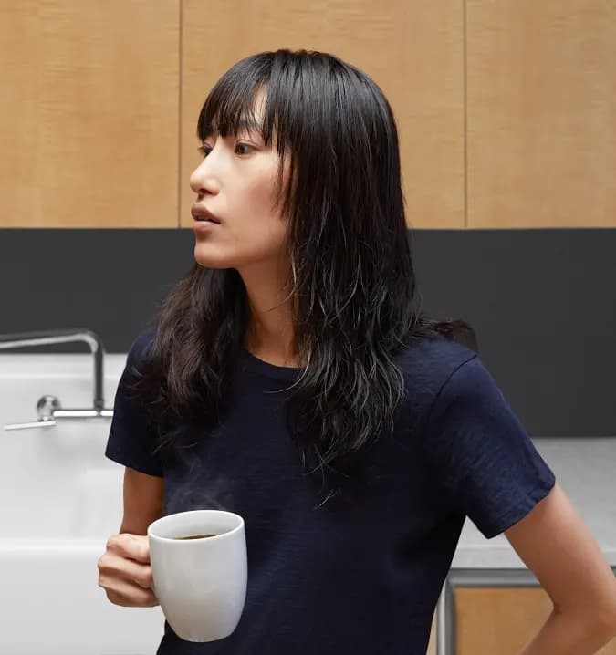 a black dressed young woman holding a cup of coffee