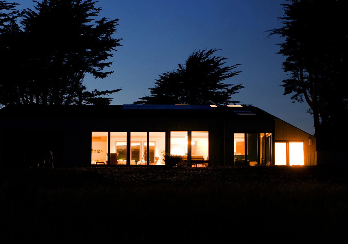 A big hourse is in the dark with all lights up.