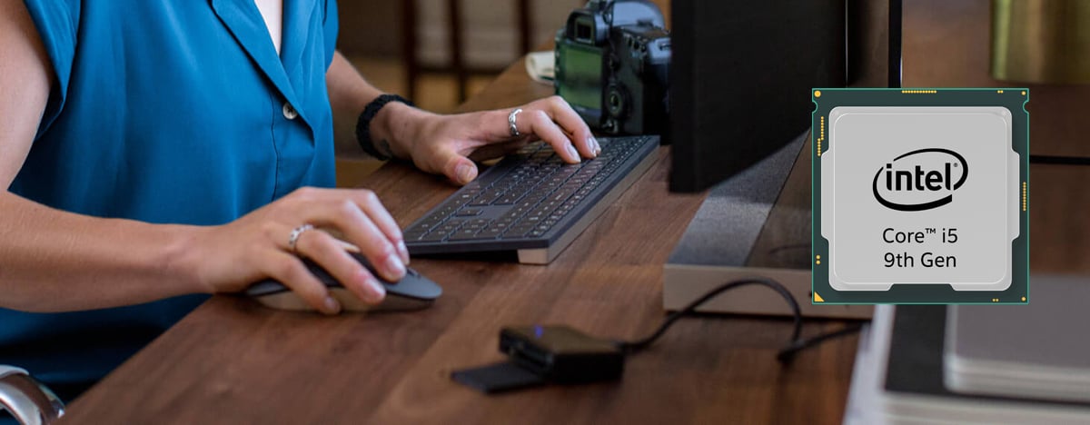 An Intel 9th Gen Core i5 processor chip is standing against a backdrop of a woman holding mouse with the right hand and pressing keys with the left hand in front of a monitor.