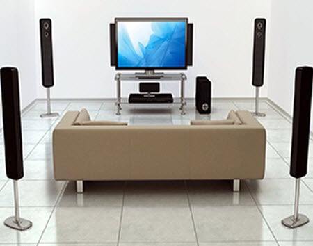 a surround sound system with a TV and a brown sofa
