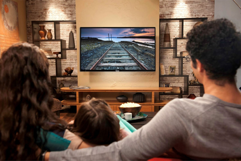 A Family in Their Living Room Watching an Avera TV 
