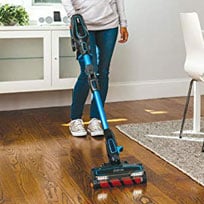 A Woman Using the Shark IF200W on a Wooden Floor in Upright Mode