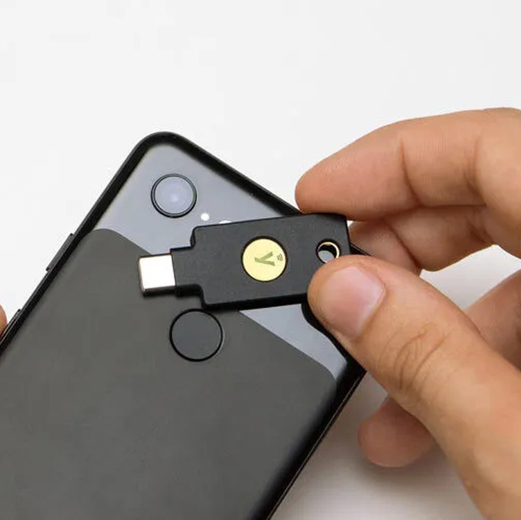 YubiKey 5C NFC FIPS being tapped against the back of a smartphone to authenticate over NFC