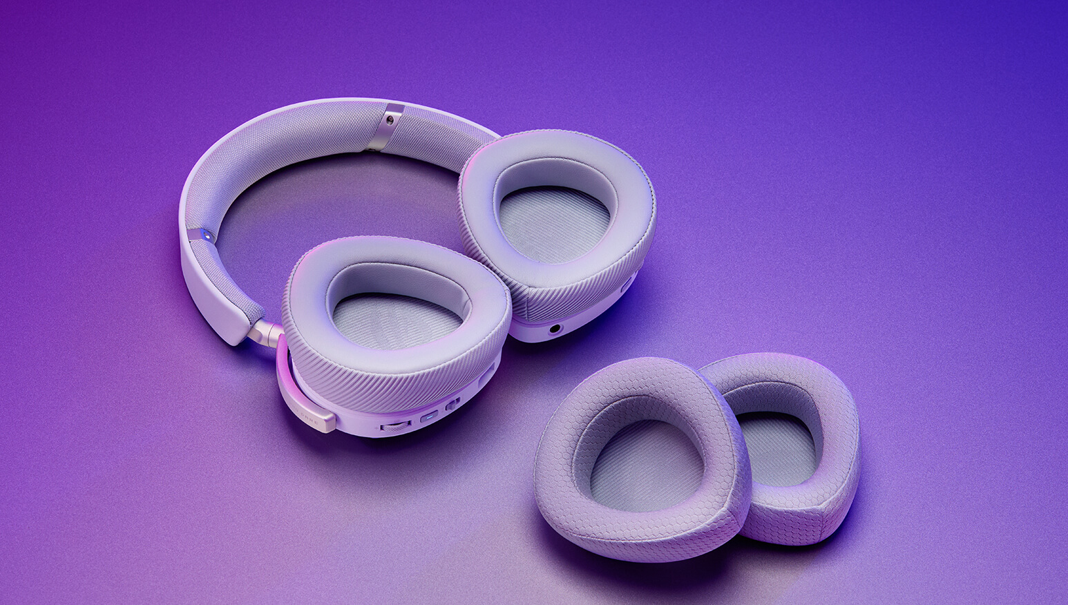 Two sets of ROG Delta II ear cushions on a table — durable PU leather on the left and breathable mesh fabric on the right