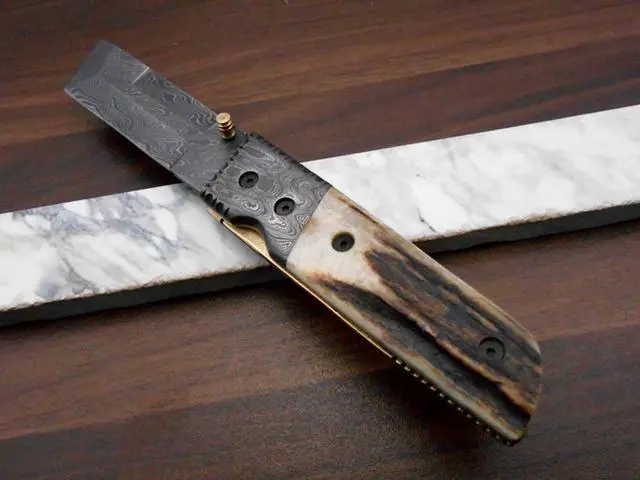 Alt view image 2 of 7 - Damascus steel Tanto blade Folding Knife, Available in Natural Ram, Bull horn, Camel Bone, Stag Antler scales with Damascus bolster, Cow hide leather sheath, equipped with Thumb knob & liner lock