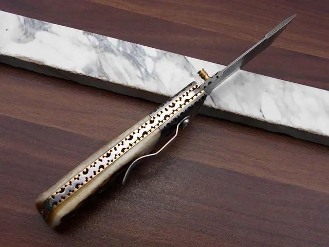 Alt view image 6 of 7 - Damascus steel Tanto blade Folding Knife, Available in Natural Ram, Bull horn, Camel Bone, Stag Antler scales with Damascus bolster, Cow hide leather sheath, equipped with Thumb knob & liner lock