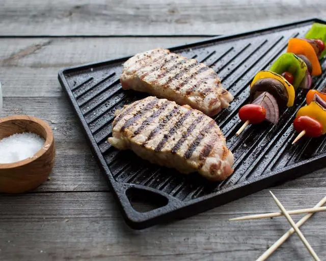 Alt view image 3 of 5 - Reversible Cast Iron Grill/Griddle C 9.5 x 16.75 Inch Pre-Seasoned Cooking Surface C Flat & Ribbed Sides C Use on Stove Grill or Campfire C Made in the USA C Heavy-Duty Black
