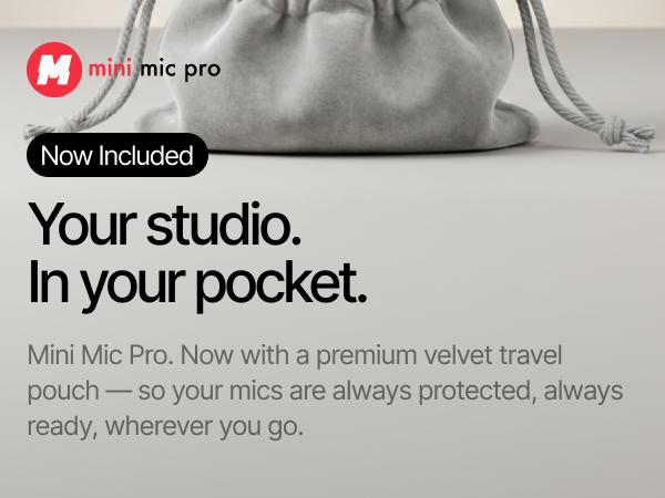 two mini mic pro wireless mics standing beside an open gray velvet travel pouch on dark background