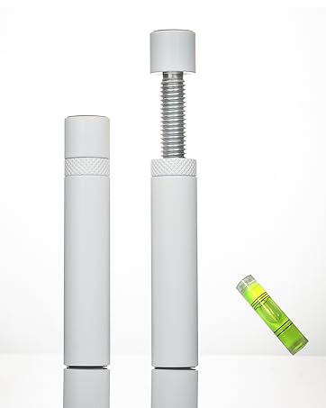 Two white cylindrical objects with threaded ends, possibly for adjustable mounting. Small green spirit level included for precise installation.