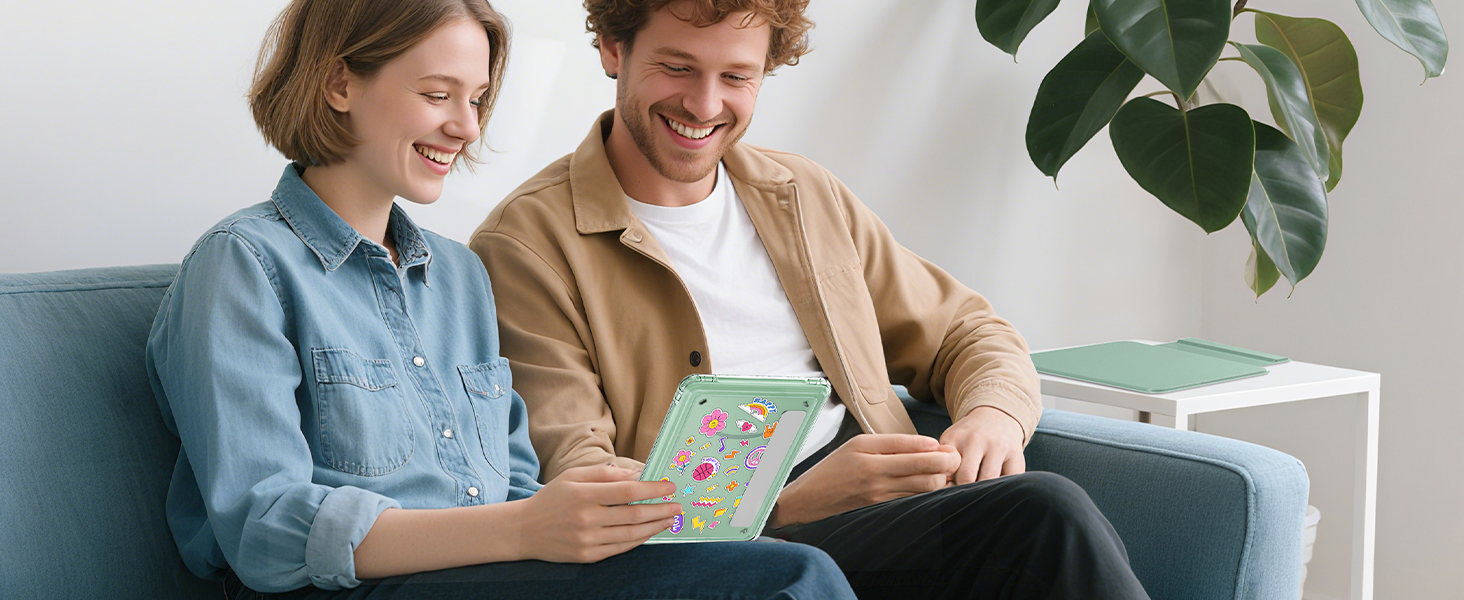 Two people sitting together on a couch looking at books or documents in a bright, modern living room setting with houseplants in the background.