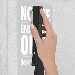 Swingline stapler tacking up a poster to a wall