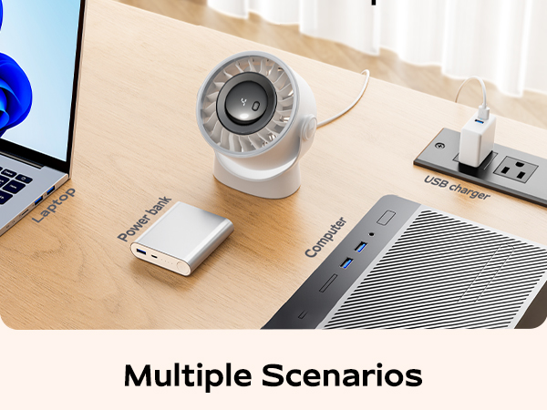 Desktop setup showing various computer peripherals including a spherical security camera, power strip, and connectivity devices on wooden surface.