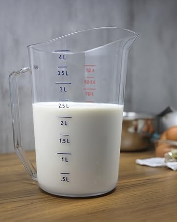 4 Liter measuring cup with milk, in a kitchen with various kitchen tools in the background.