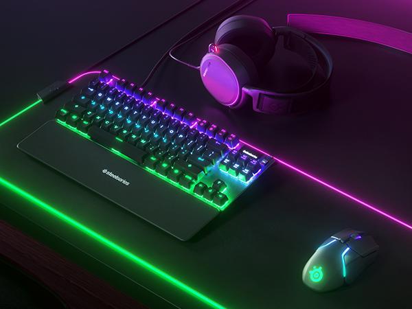 - A SteelSeries desk setup with Apex TKL keyboard, Rival mouse, Arctis headset, and QcK mousepad