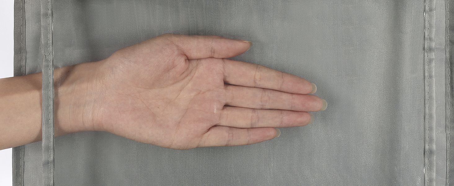 Hand pressing against a textured gray fabric surface, demonstrating its elasticity and texture.
