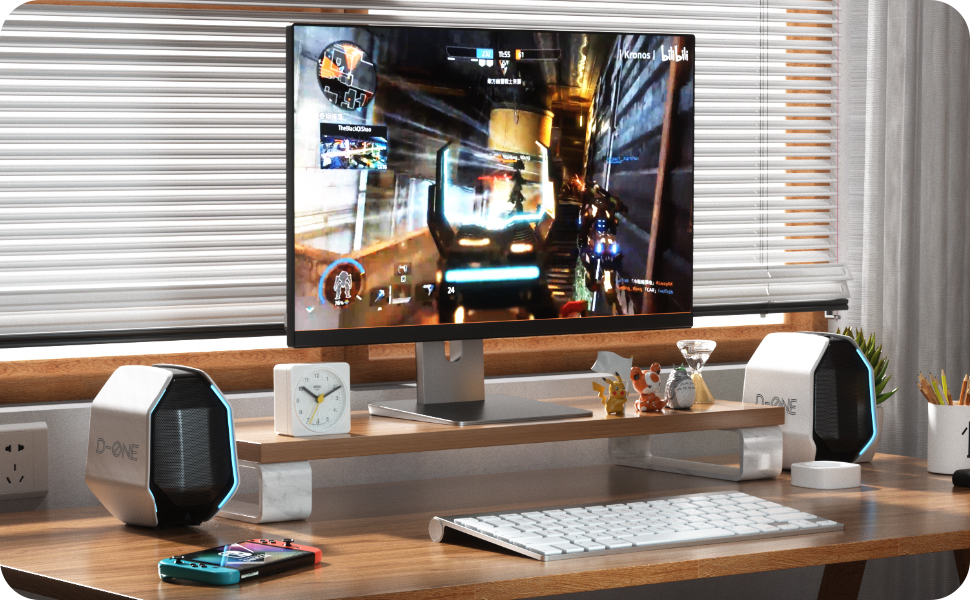 Home entertainment or gaming desk setup featuring D-ONE speakers