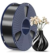 Large spool of metallic gray 3D printer filament on blue perforated holder. Black spiral-patterned vase with white flowers beside it for scale comparison.