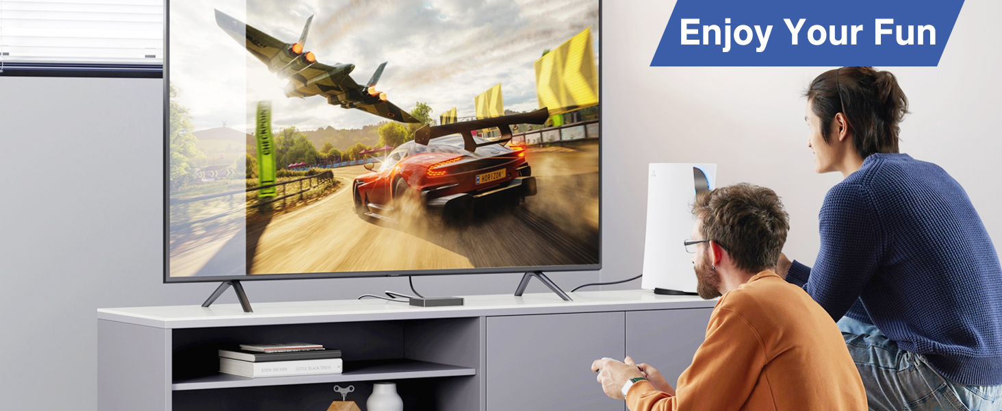 Text reads 'Enjoy Your Fun'. Multiple panels showing people using gaming or entertainment setup in living room environment with large screen displays.