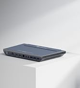 Gray rectangular network switch or router with multiple ports visible on the front, positioned on a white surface against a light background.