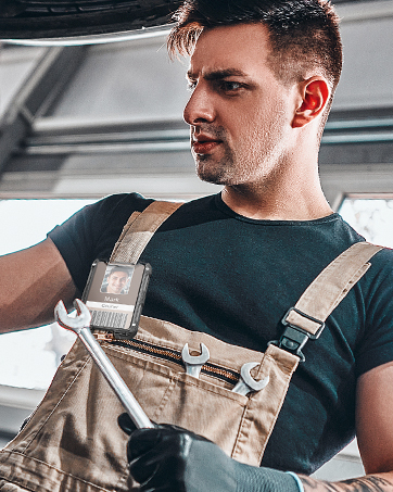 A scene of a mechanic wearing a badge holder on his chest.