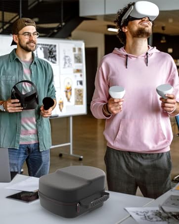 Two people wearing VR headsets in an office setting. One in pink hoodie using handheld controllers, another in green jacket holding a headset.