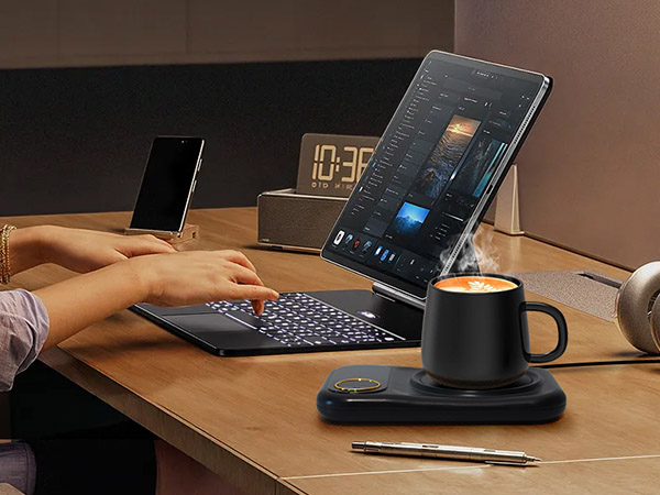 Desktop workspace setup showing laptop, digital clock display, and desk accessories in low-light conditions with ambient lighting.