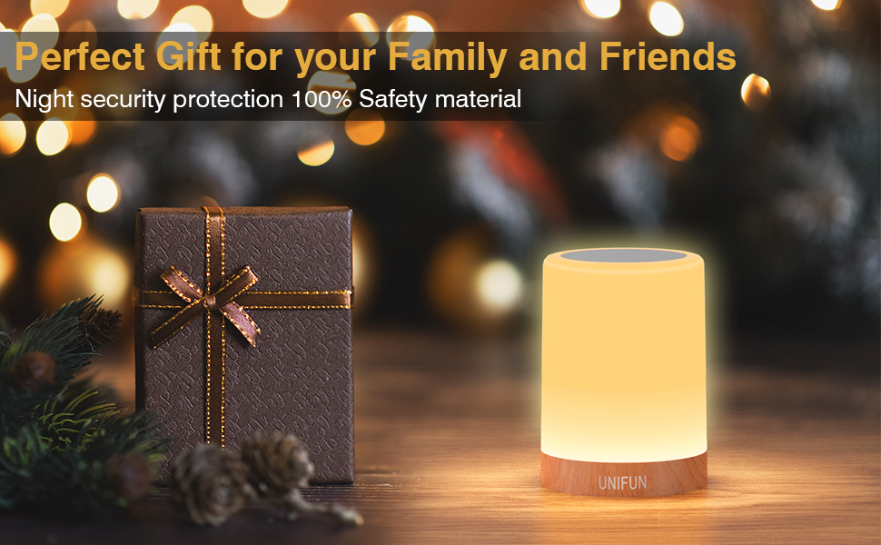 Cylindrical yellow table lamp with soft glow, next to a wrapped gift box. Text indicates it's a night security light made with safety material.