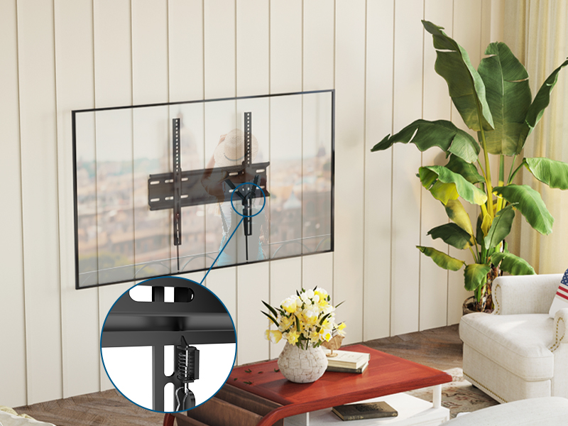 Wall-mounted TV bracket in living room setting. Inset image shows bracket details. Red table and potted plant visible in foreground.
