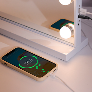 Smartphone displaying a glowing green interface lying on a white surface, showing wireless charging or connectivity status.