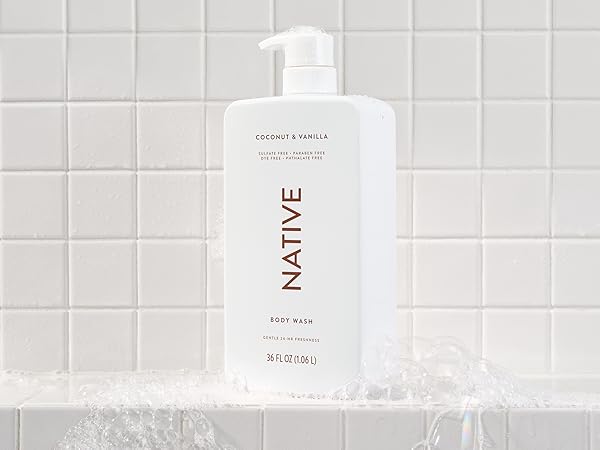 Native&amp;amp;#39;s coconut and vanilla sulfate-free bodywash shown in a shower with suds around it