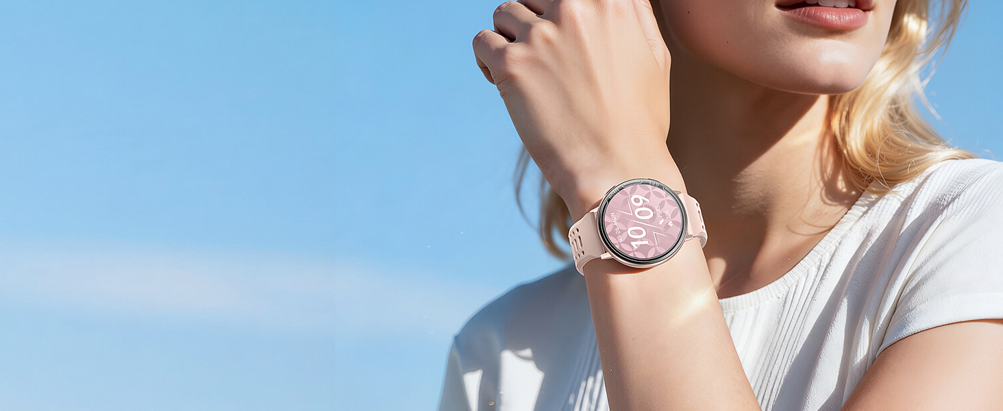 Wristwatch with pink/rose colored face and band shown being worn against blue sky background.