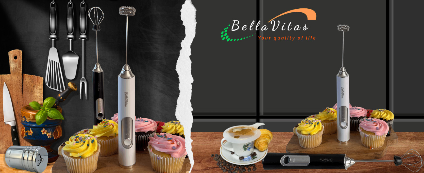 White and black milk frothers, cupcakes, cocoa shaker, utensils, and espresso on a kitchen board.