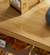 Partial view of a wooden surface, possibly a table or shelf. Limited context provided in the image.