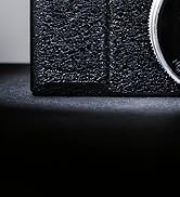 Multiple close-up views of a black textured circular object with reflective elements and curved edges against a dark background.