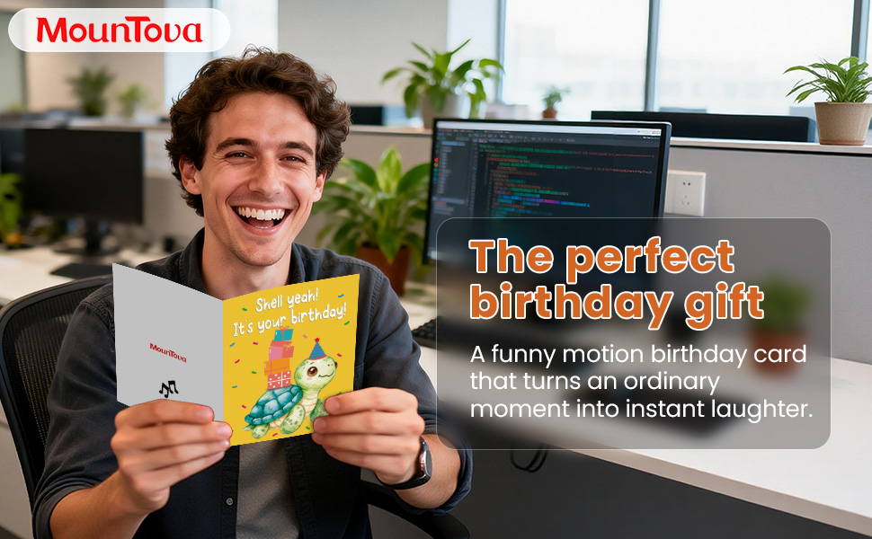 A man opening a funny musical turtle pop-up birthday card at his office desk, smiling happily