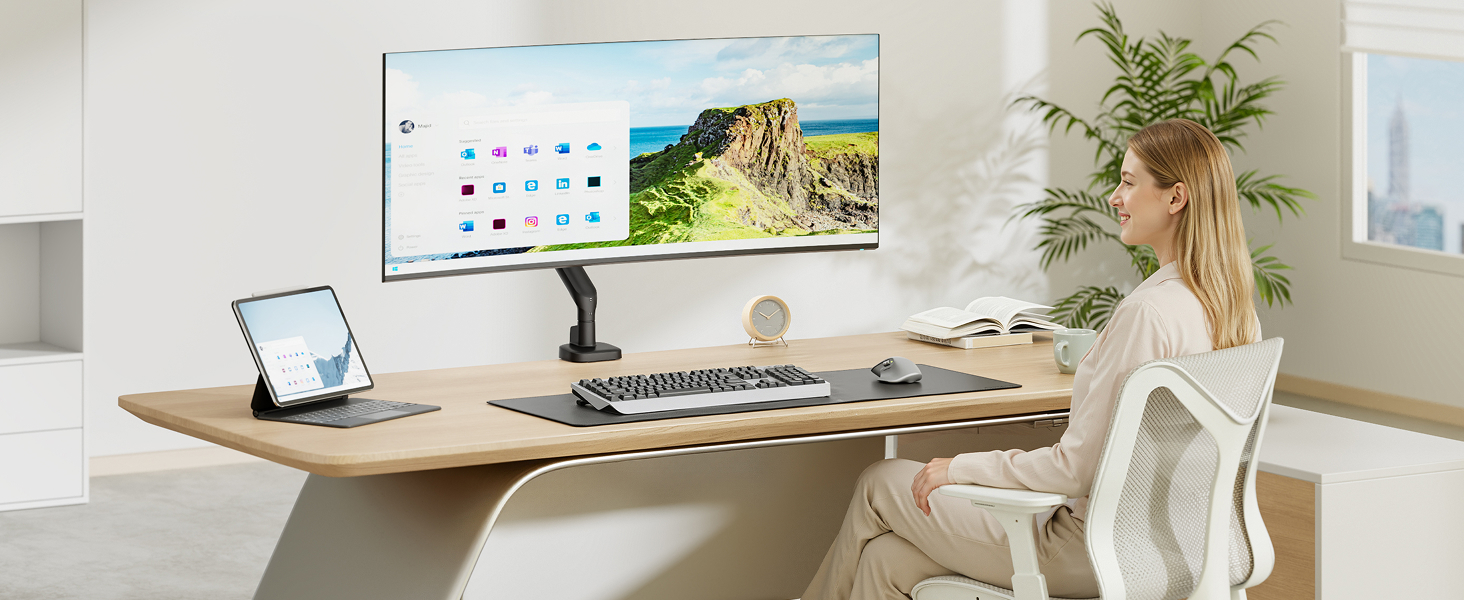 Modern home office workspace featuring desk with laptop, monitor, decorative plant in white pot, and minimalist décor.