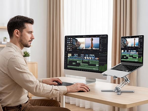 Person working at desk setup with dual monitor display, showing professional workspace configuration with modern computing equipment.