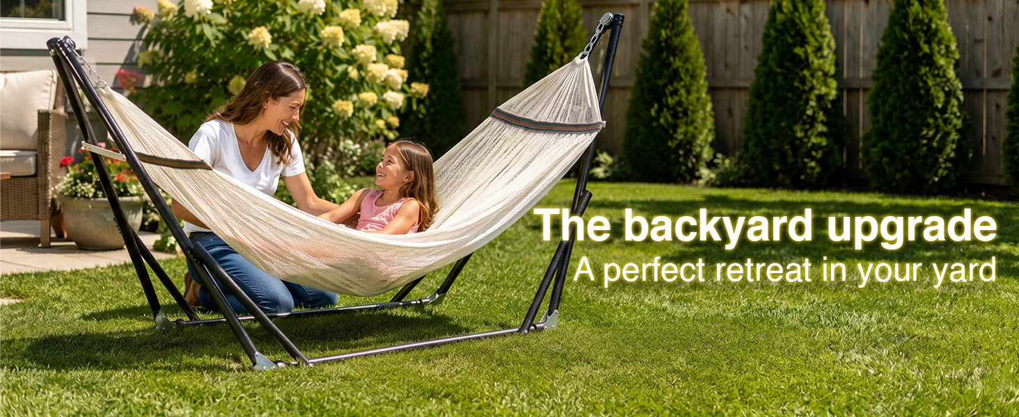 Mother and daughter relax in the comfort of their backyard on a portable hammock with stand