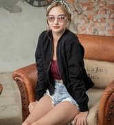 3.4 J+S Vision Hali Sunglasses - girl wearing round retro clear frame pink mirror lens sitting on a