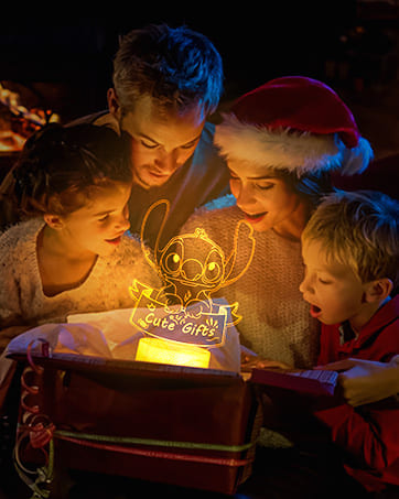 Glowing 3D night light creating a magical atmosphere. Children gathered around, illuminated by warm light from the decorative lamp.