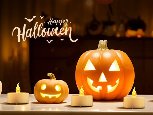 Halloween decoration with illuminated jack-o'-lanterns. Large orange pumpkin with triangle eyes and mouth, smaller smiling pumpkin, surrounded by lit tea light candles. 'Happy Halloween' text visible.