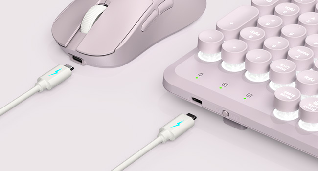 Purple keyboard and mouse charging via USB-C—rechargeable convenience with no disposable batteries.