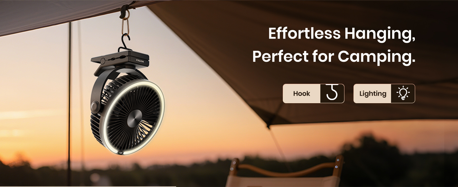 Black clip-on fan with hook and lighting, hanging from a tent at a camping site during sunset.